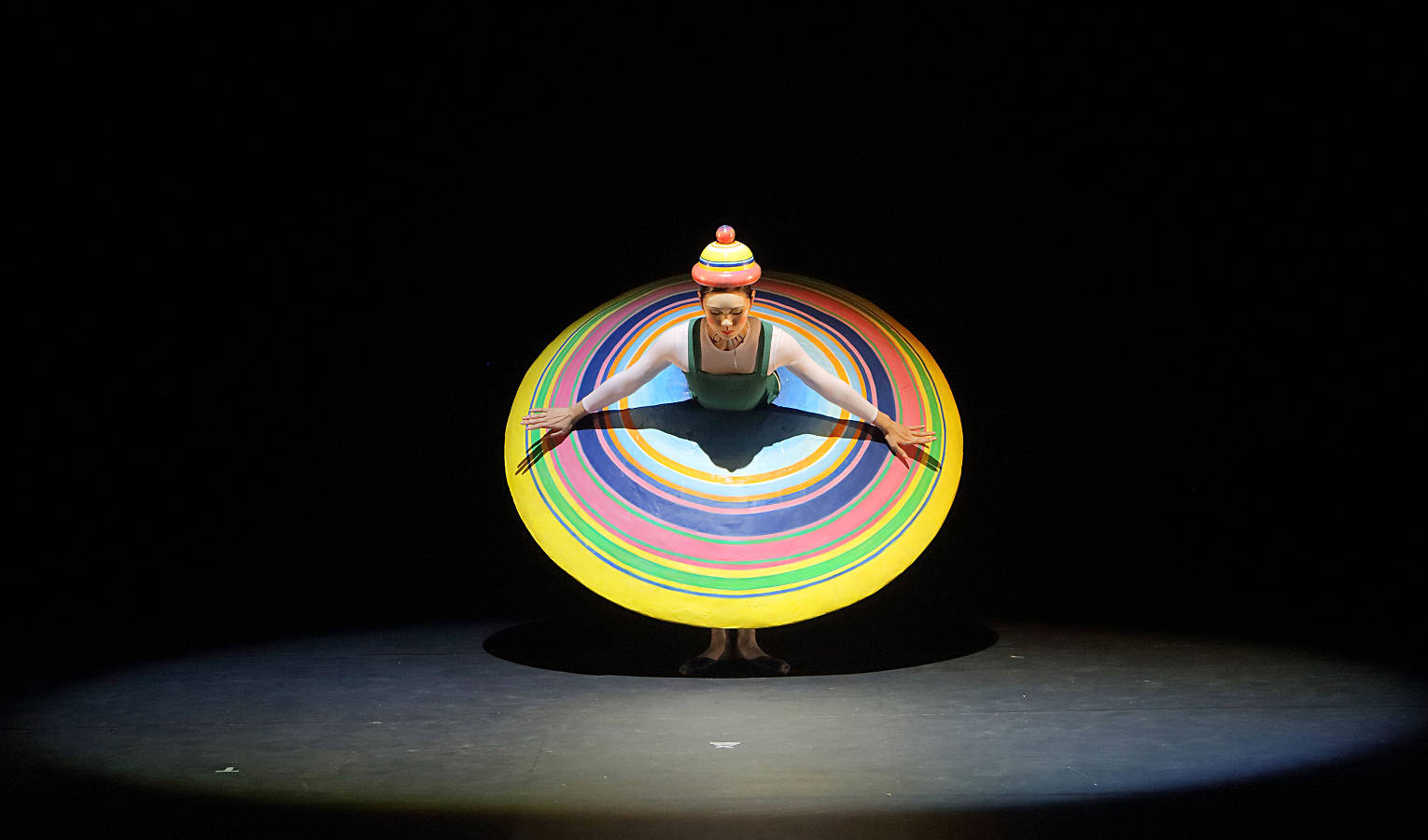 Kobieta w okrągłej sukni ze wzorem koncentrycznych, kolorowych okręgów