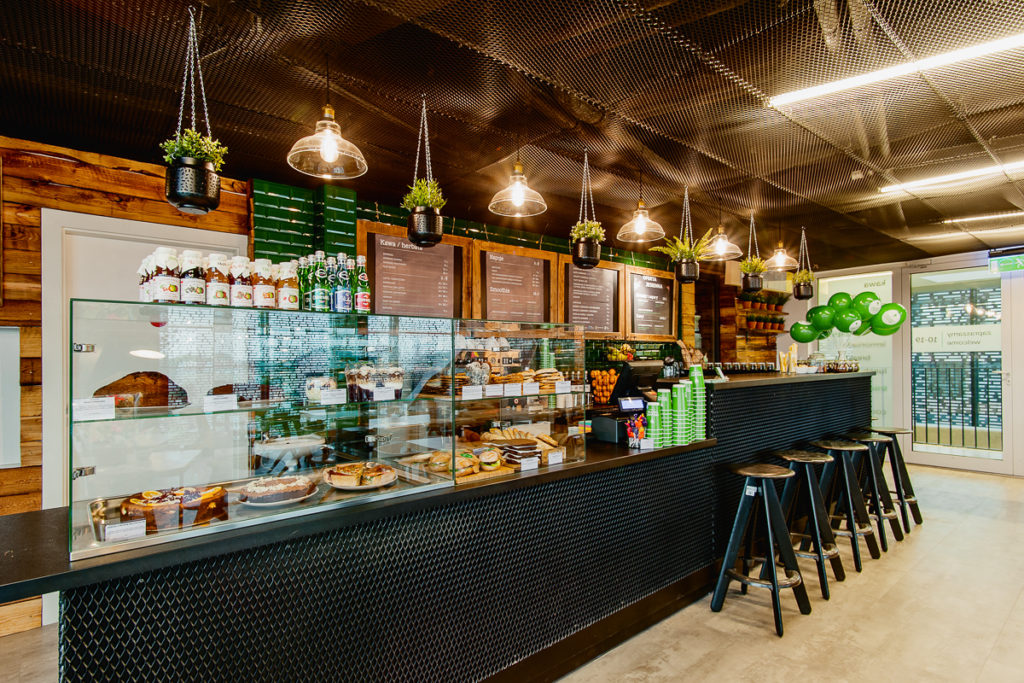Widok baru w kawiarni w Cricotece. Stołki barowe, bar oraz witryna z potrawami