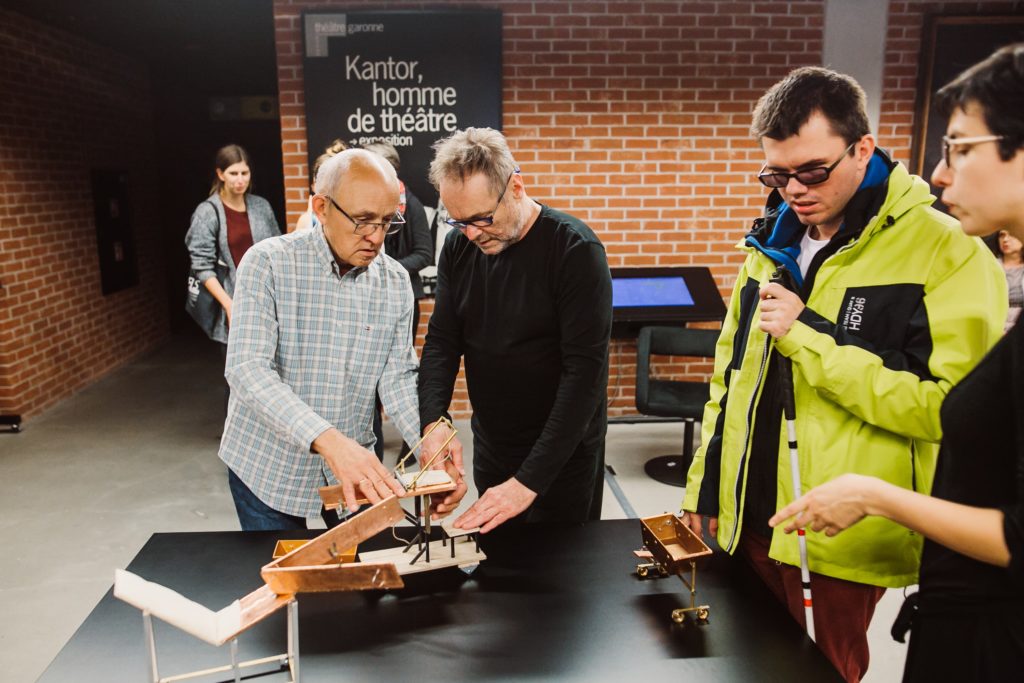 Na zdjęciu: osoby dotykają replik obiektów-replik miniatur obiektów ze spektakli Tadeusza Kantora.