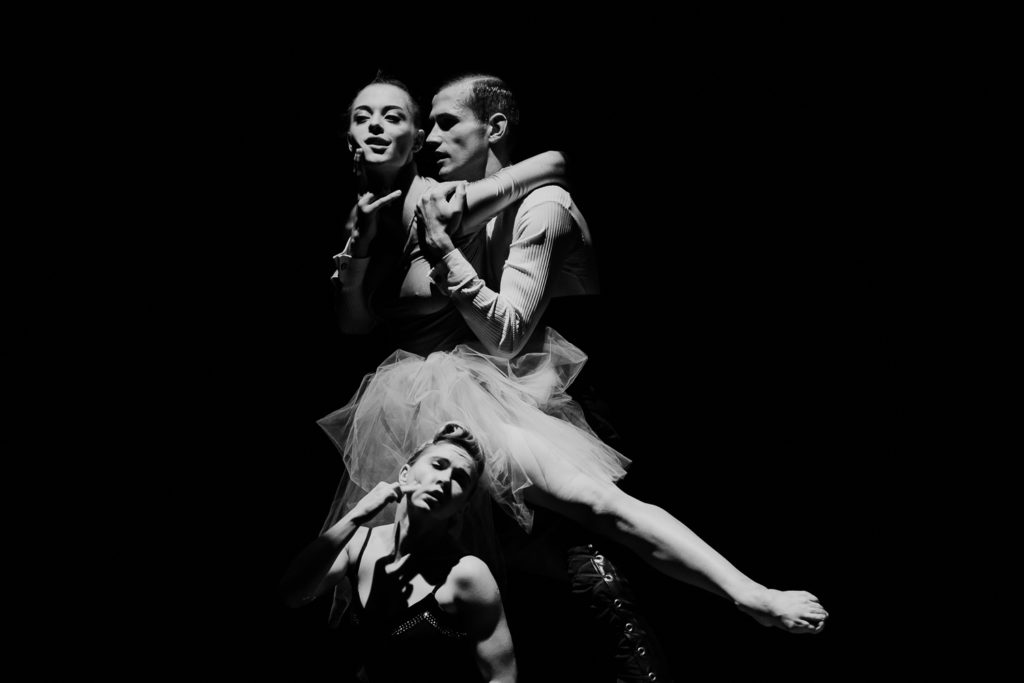 Na czarno-białej fotografii widsać trójkę tancerzy: dwie kobiety, jednego mężczyznę