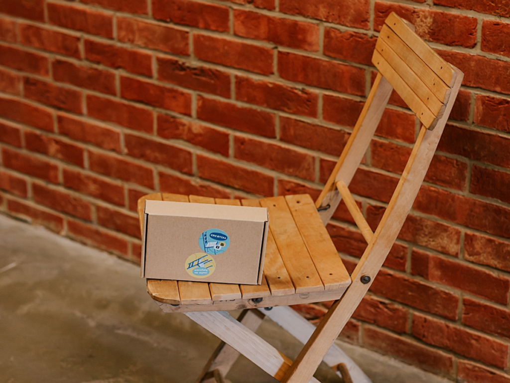 Zdjęcie kartonowego pudełka leżacego na drewnianym krzesełku