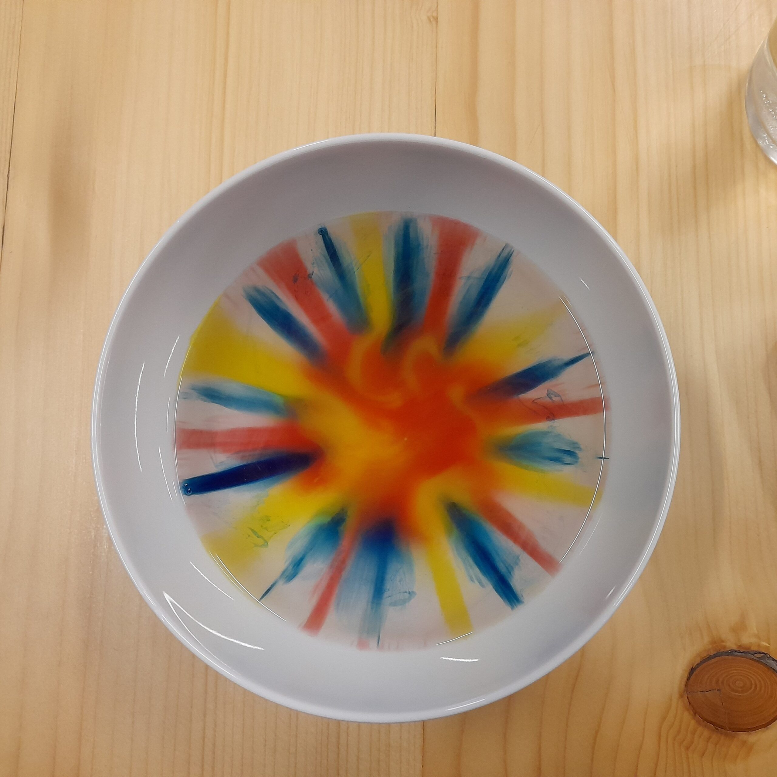 Zdjęcie przedstawia miskę wypełnioną kolorowymi płynami