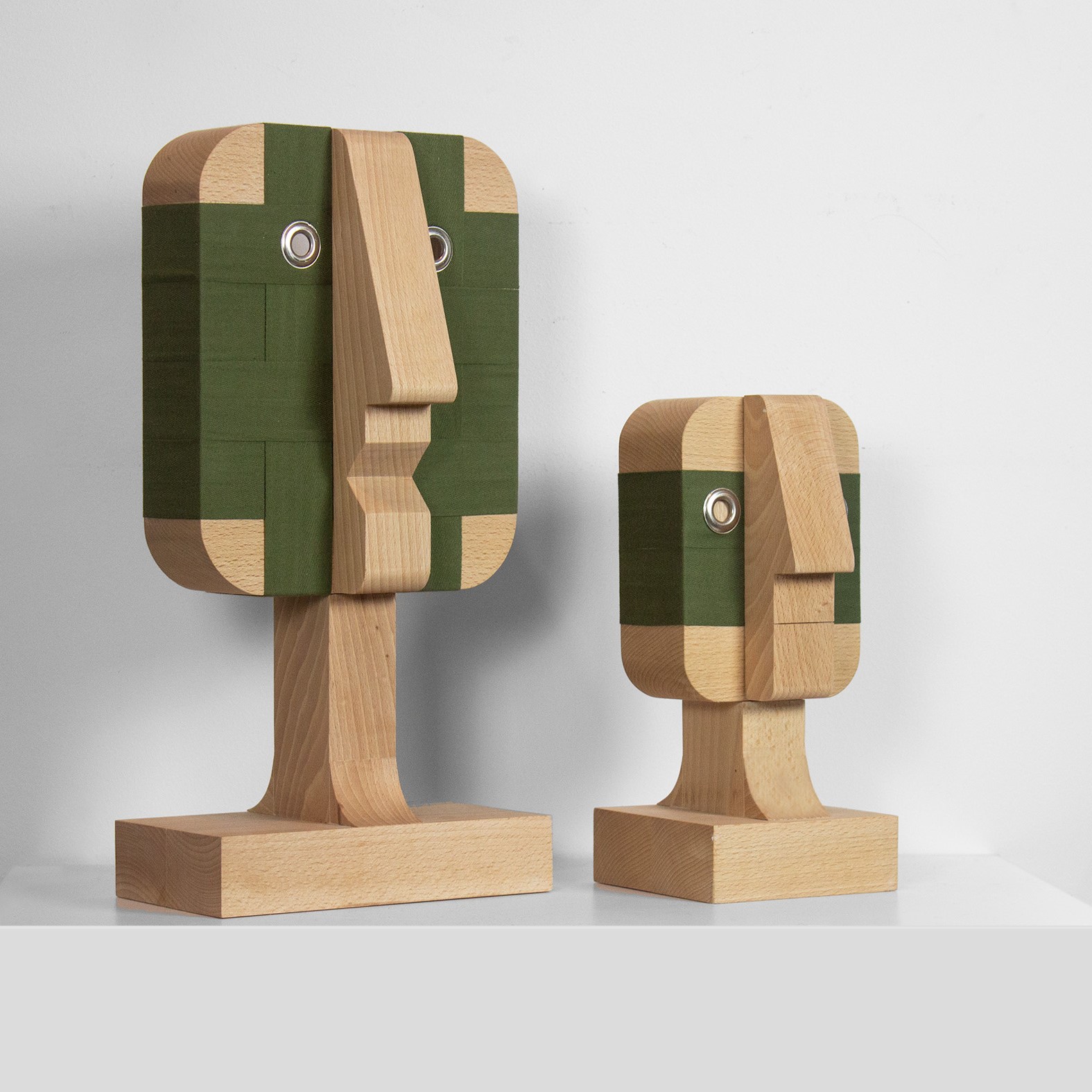 Fotografia przedstawia dwie rzeźby Bartosza Muchy przypominające zgeometryzowane ludzkie twarze. Praca zatytułowana jest "Małe tapczany"