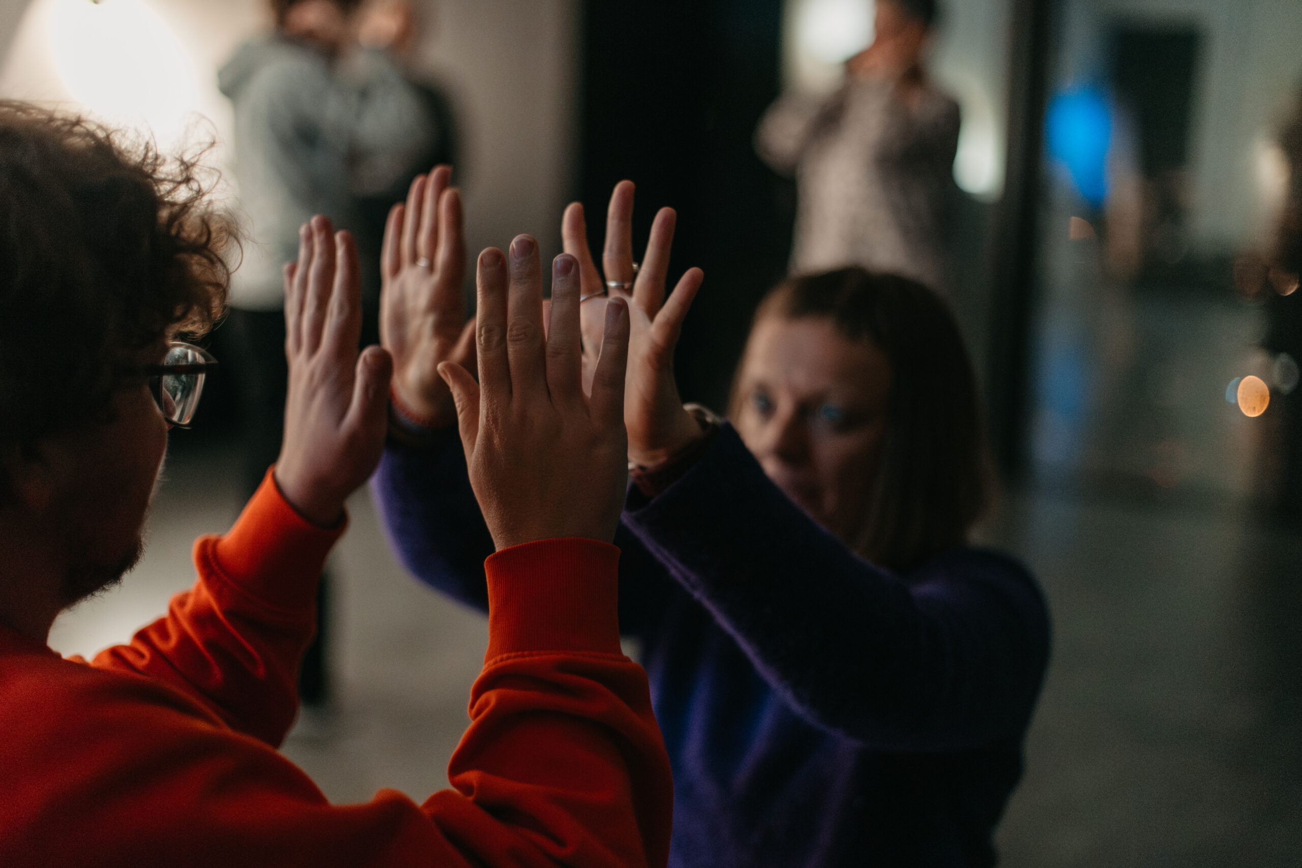 zdjęcie 2 osób mężczyzna i kobieta stoją twarzami do siebie z rękami w górze, ich dłonie niemalże się dotykają