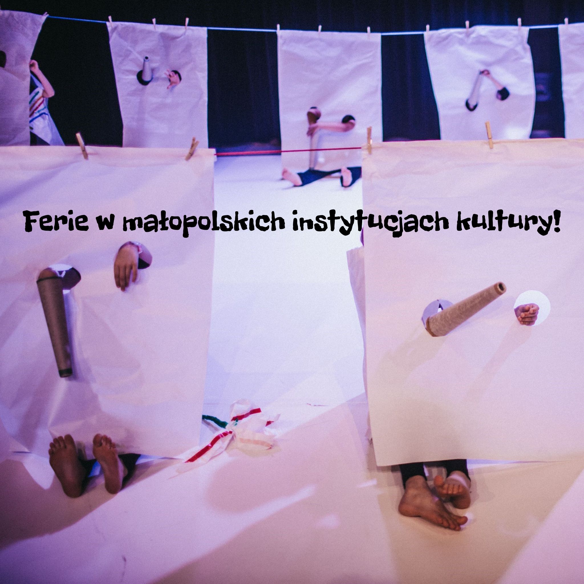 Grafika przedstawia artystyczną scenę: kilka dużych białych arkuszy papieru zawieszonych na sznurkach jak pranie, zza których wystają dziecięce ręce, nogi, stopy. trzymające różne przedmioty, oświetlone teatralnym, fioletowo-niebieskim światłem. Na środku obrazu widnieje czarny napis: „Ferie w małopolskich instytucjach kultury!”.