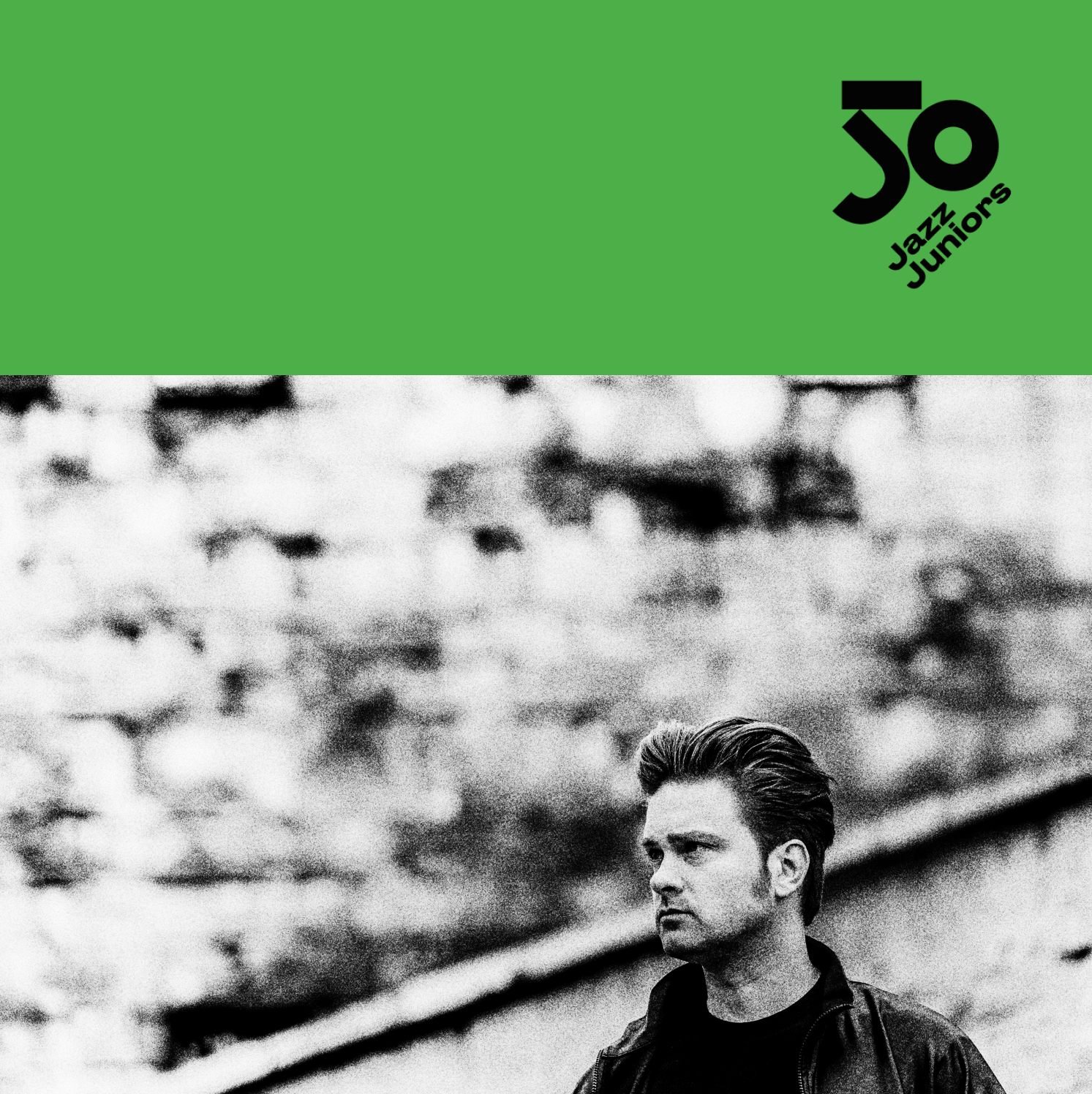 Grafika festiwalu 50 Jazz Juniors. Górna część w jaskrawo zielonym kolorze z czarnym logo 50 Jazz Juniors w prawym rogu. Dolna część to czarno-białe zdjęcie młodego mężczyzny z zaczesanymi do tyłu włosami, ubranego w ciemną kurtkę. Mężczyzna patrzy w lewo, w tle rozmyty mur z cegły.